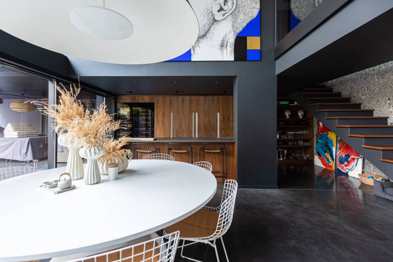 Maison contemporaine en béton noir avec passerelle en verre et terrasse sur piscine près de Bordeaux