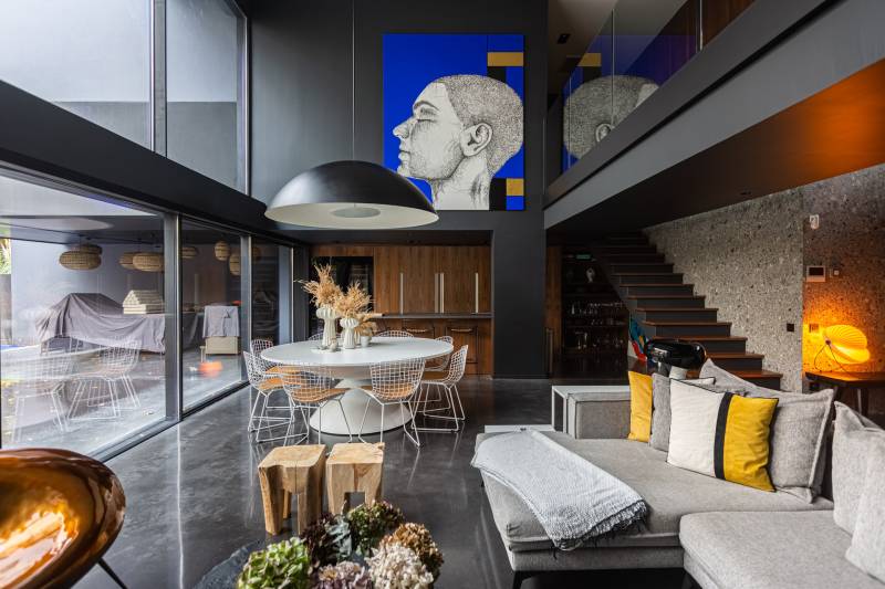 Maison contemporaine en béton noir avec passerelle en verre et terrasse sur piscine près de Bordeaux