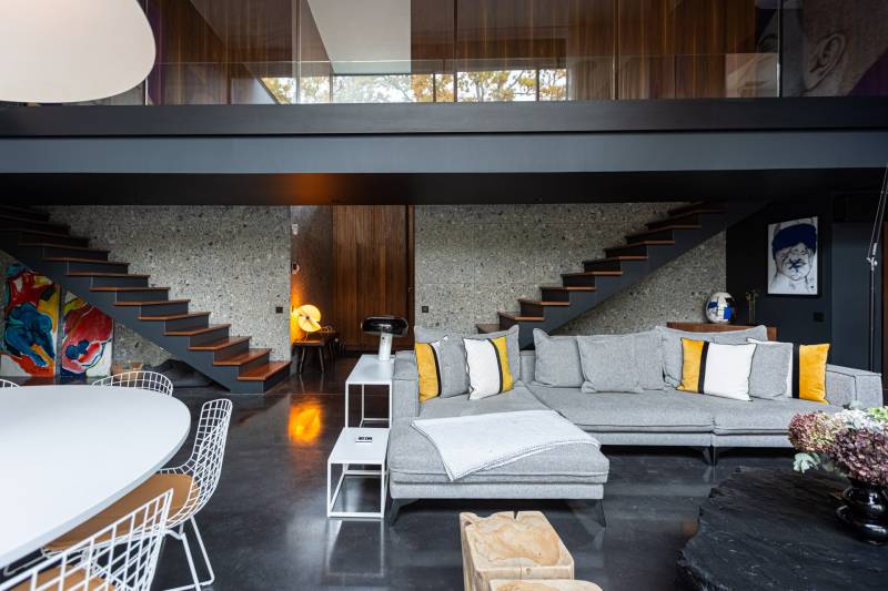 Maison contemporaine en béton noir avec passerelle en verre et terrasse sur piscine près de Bordeaux