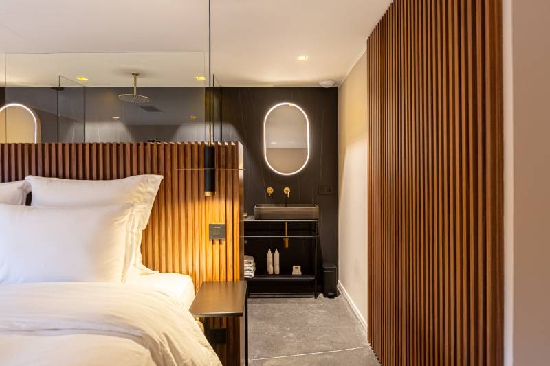 Maison contemporaine en béton noir avec passerelle en verre et terrasse sur piscine près de Bordeaux