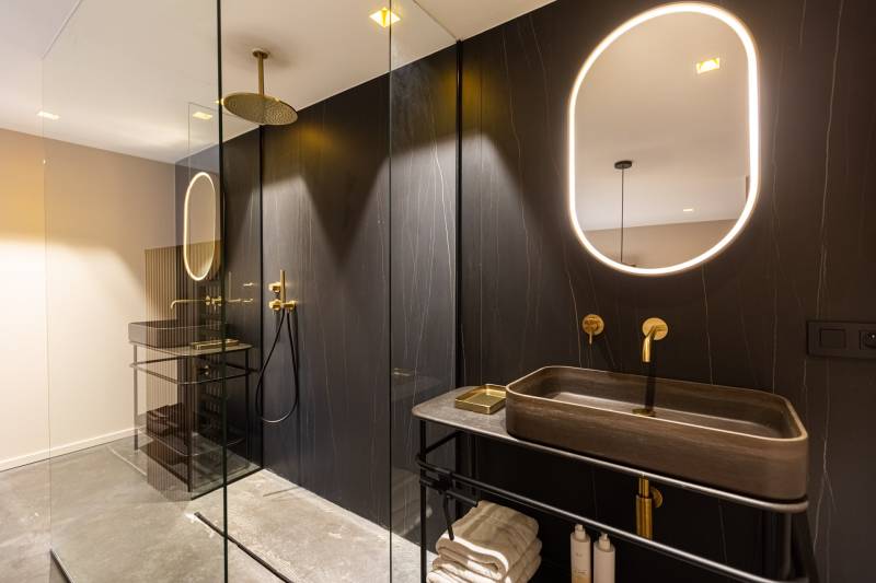 Maison contemporaine en béton noir avec passerelle en verre et terrasse sur piscine près de Bordeaux