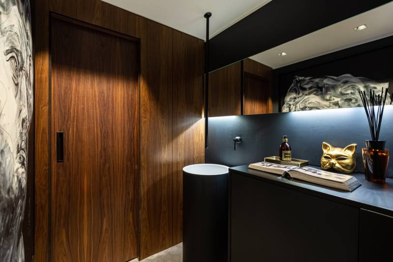 Maison contemporaine en béton noir avec passerelle en verre et terrasse sur piscine près de Bordeaux