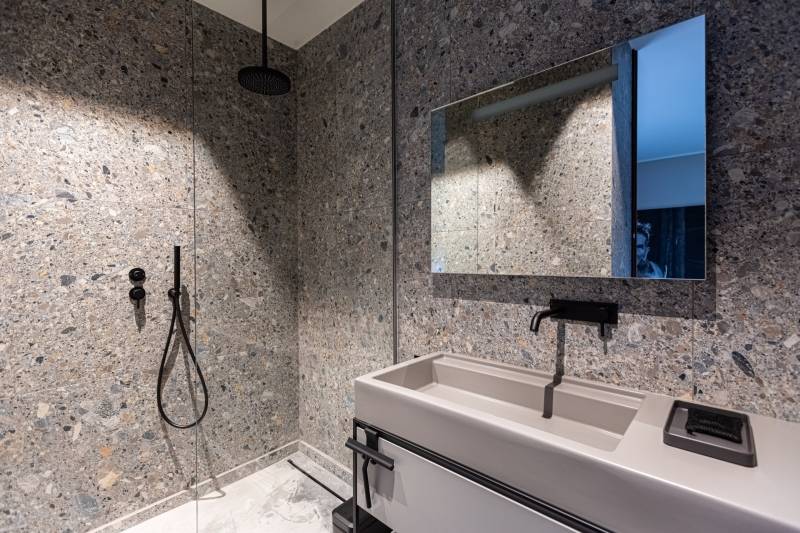 Maison contemporaine en béton noir avec passerelle en verre et terrasse sur piscine près de Bordeaux